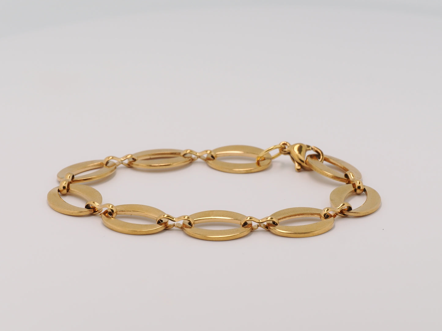 Gold bracelet on a light gray background