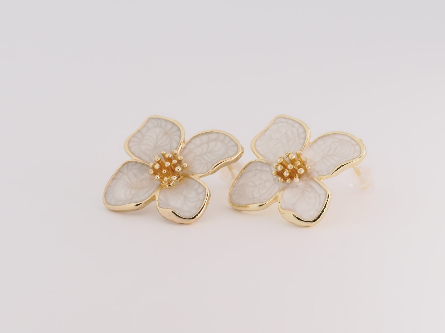 Floral earrings with gold accents on a light gray background