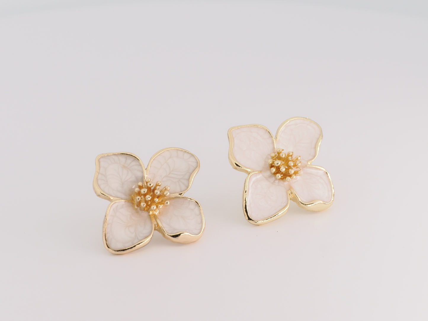 Floral earrings with gold accents on a light gray background