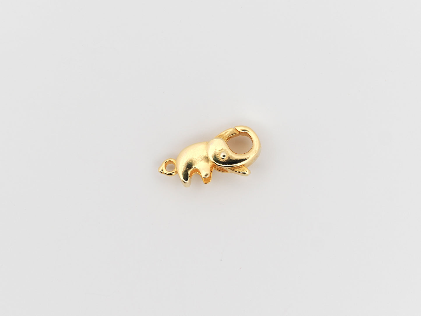 Gold elephant-shaped charm on a light gray background