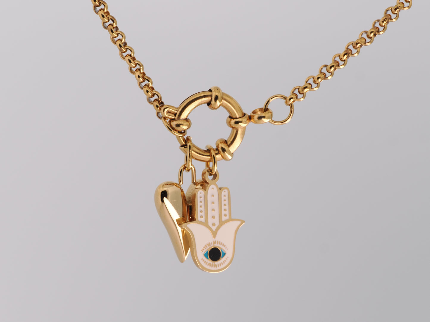 Gold necklace with a Hamsa hand pendant on a gray background