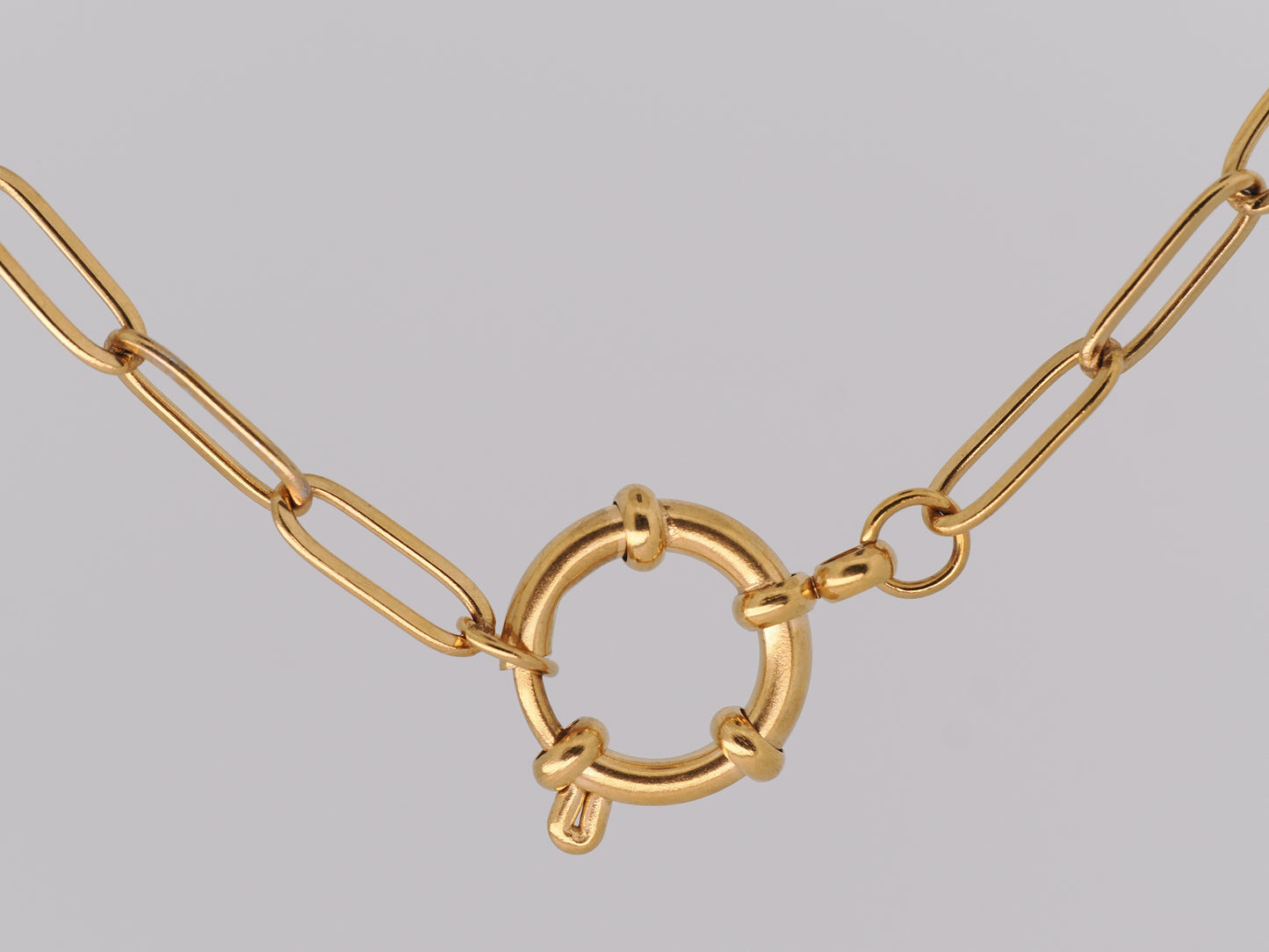 Gold chain necklace on a gray background