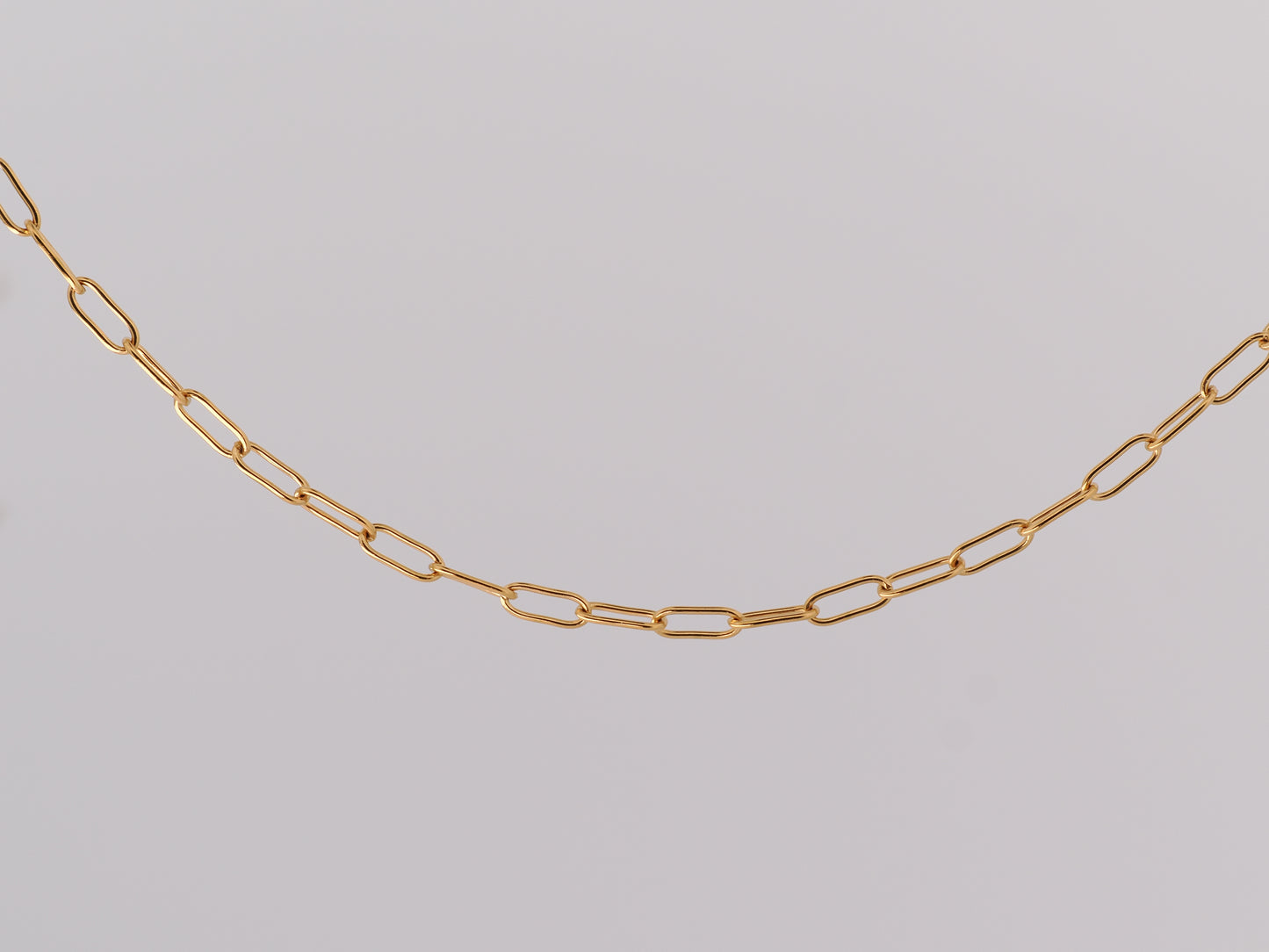 Gold chain on a light gray background