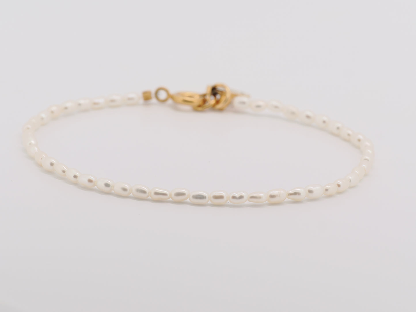 Gold bracelet on a light gray background