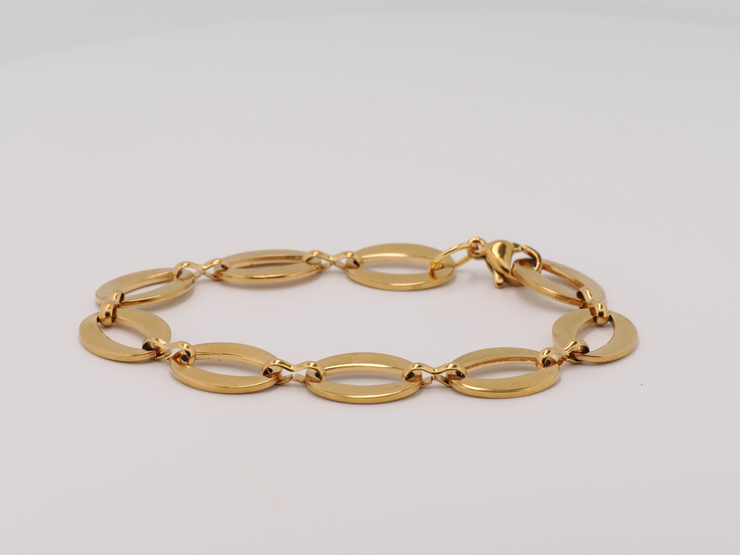 Gold bracelet on a light gray background