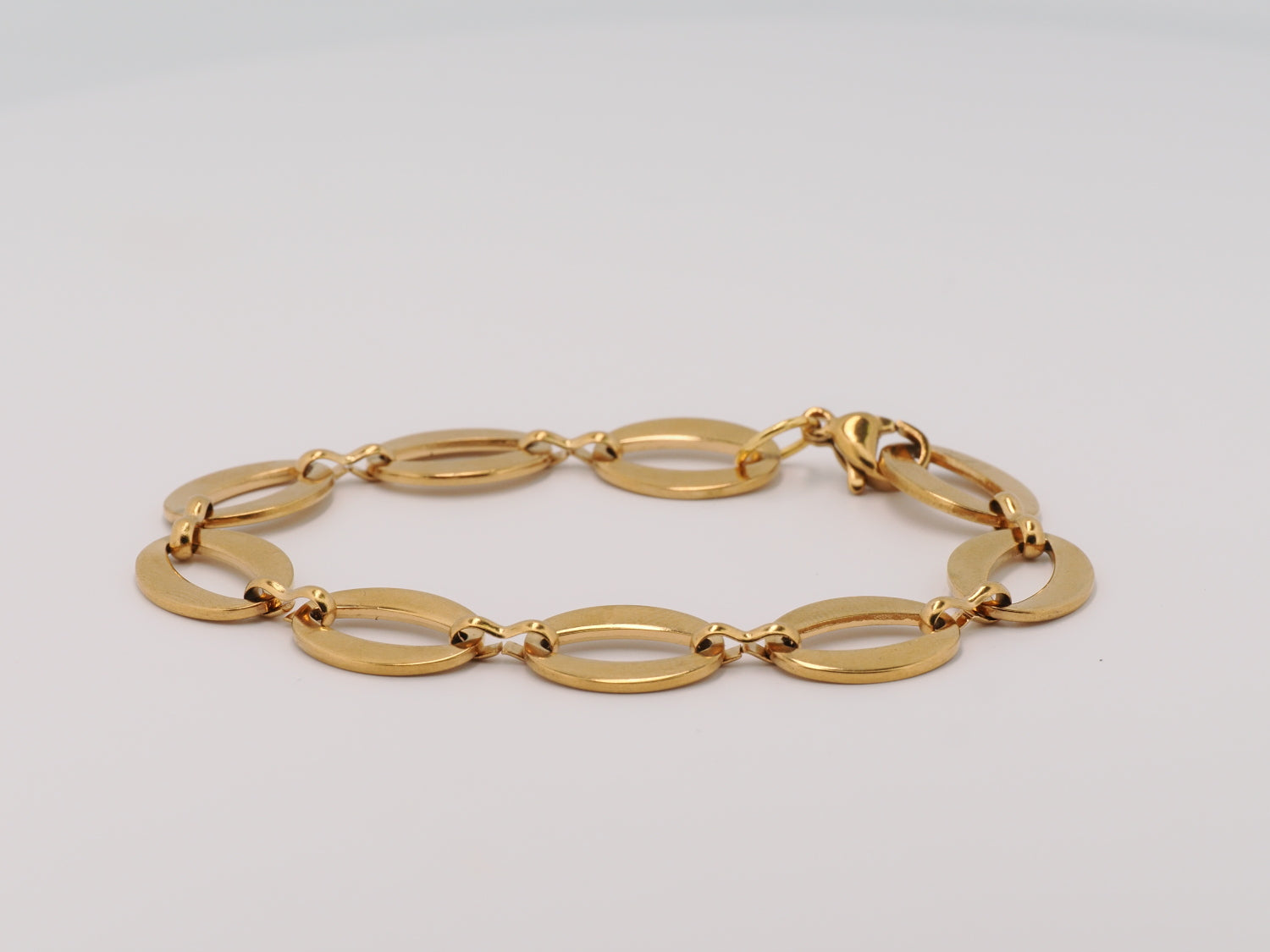 Gold bracelet on a light gray background