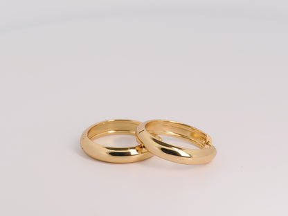 Two gold rings on a light gray background