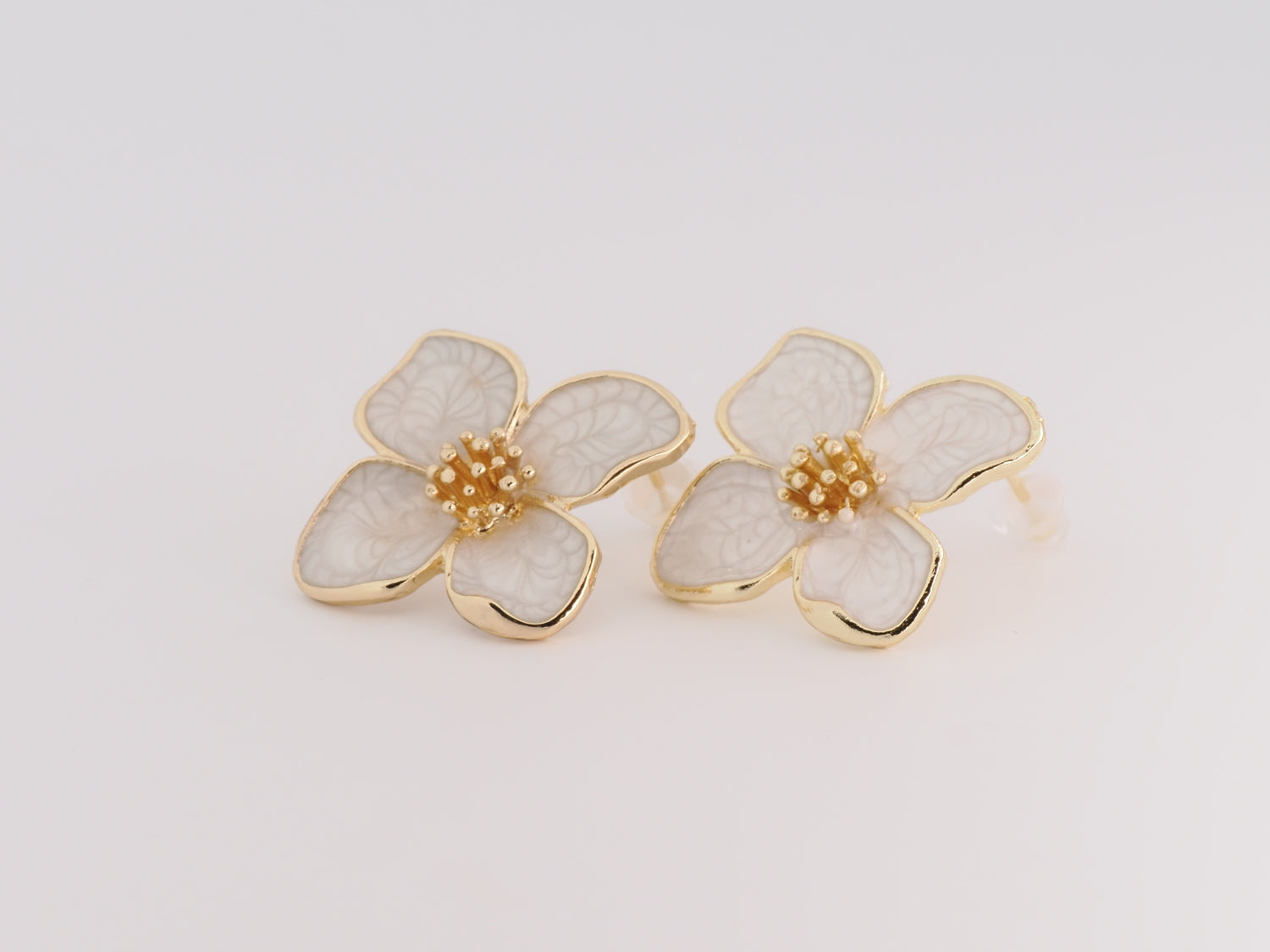 Floral earrings with gold accents on a light gray background