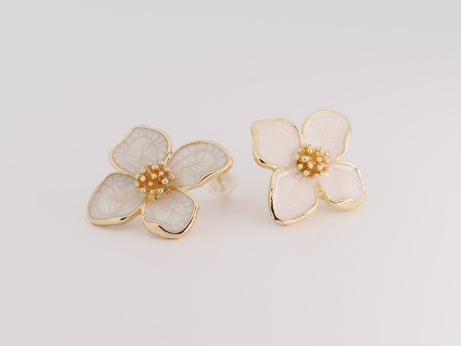 Floral earrings with gold accents on a light gray background