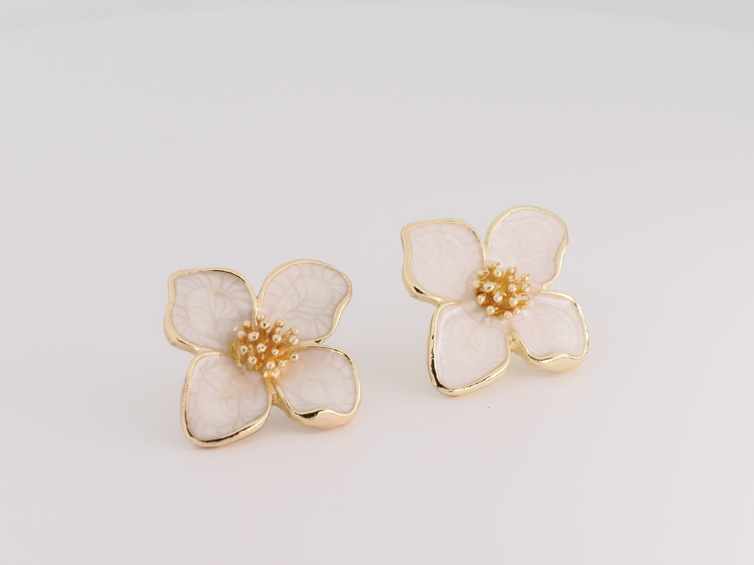 Floral earrings with gold accents on a light gray background