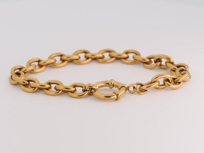 Gold chain bracelet on a light gray background