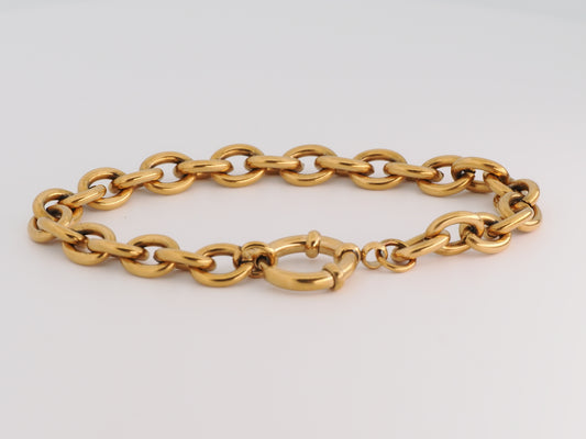 Gold chain bracelet on a light gray background