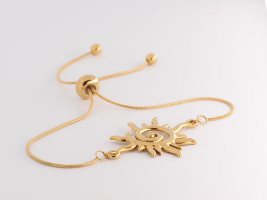 Gold bracelet with sun design on a white background