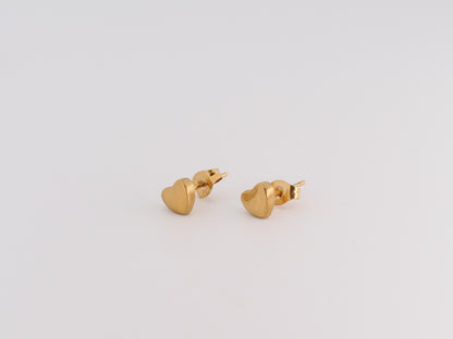 Gold heart-shaped earrings on a light gray background