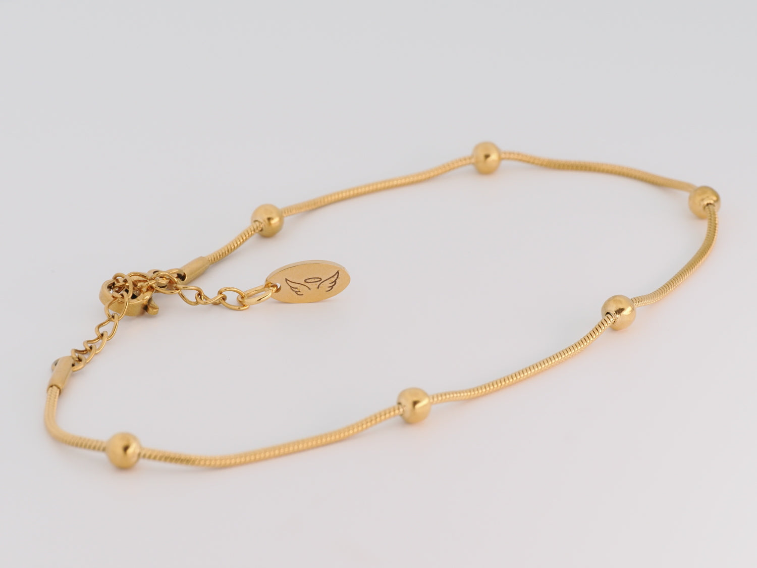 Gold bracelet on a light gray background