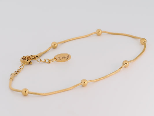 Gold bracelet on a light gray background
