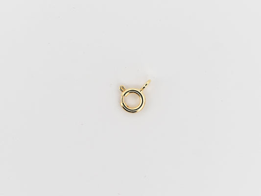 Gold necklace clasp on a light gray background