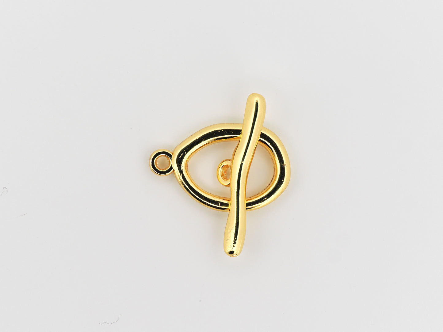 Gold treble clef pendant on a light gray background
