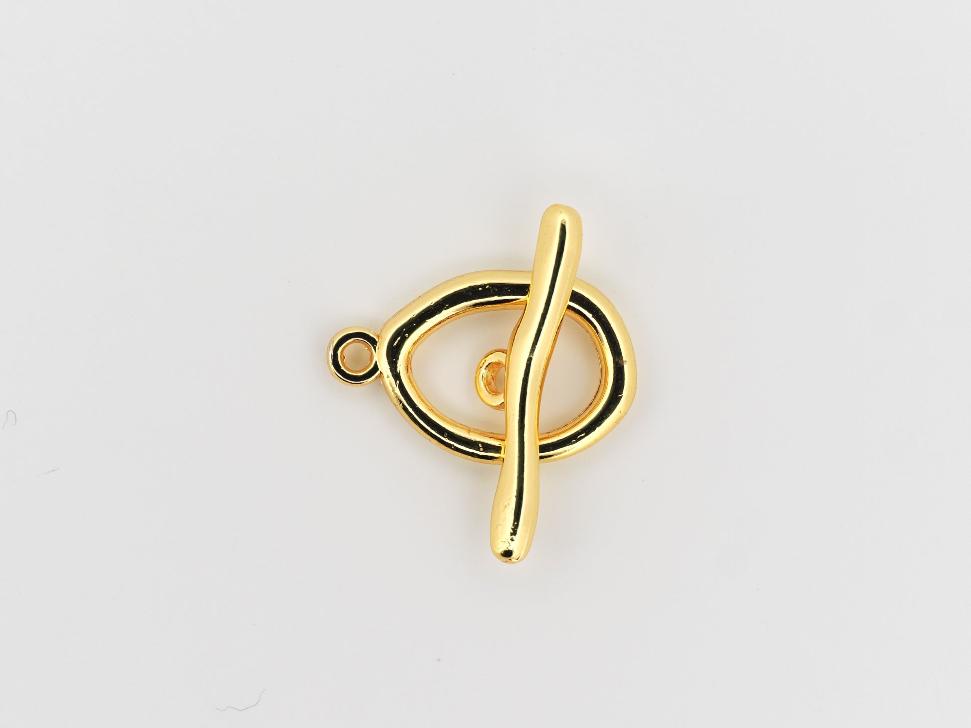 Gold treble clef pendant on a light gray background