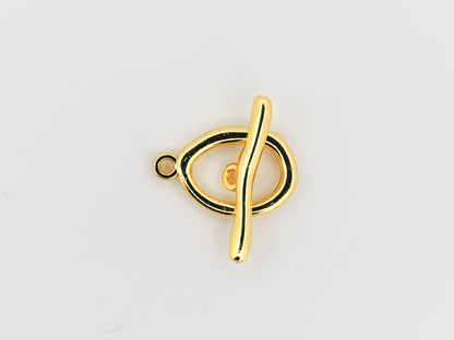 Gold treble clef pendant on a light gray background