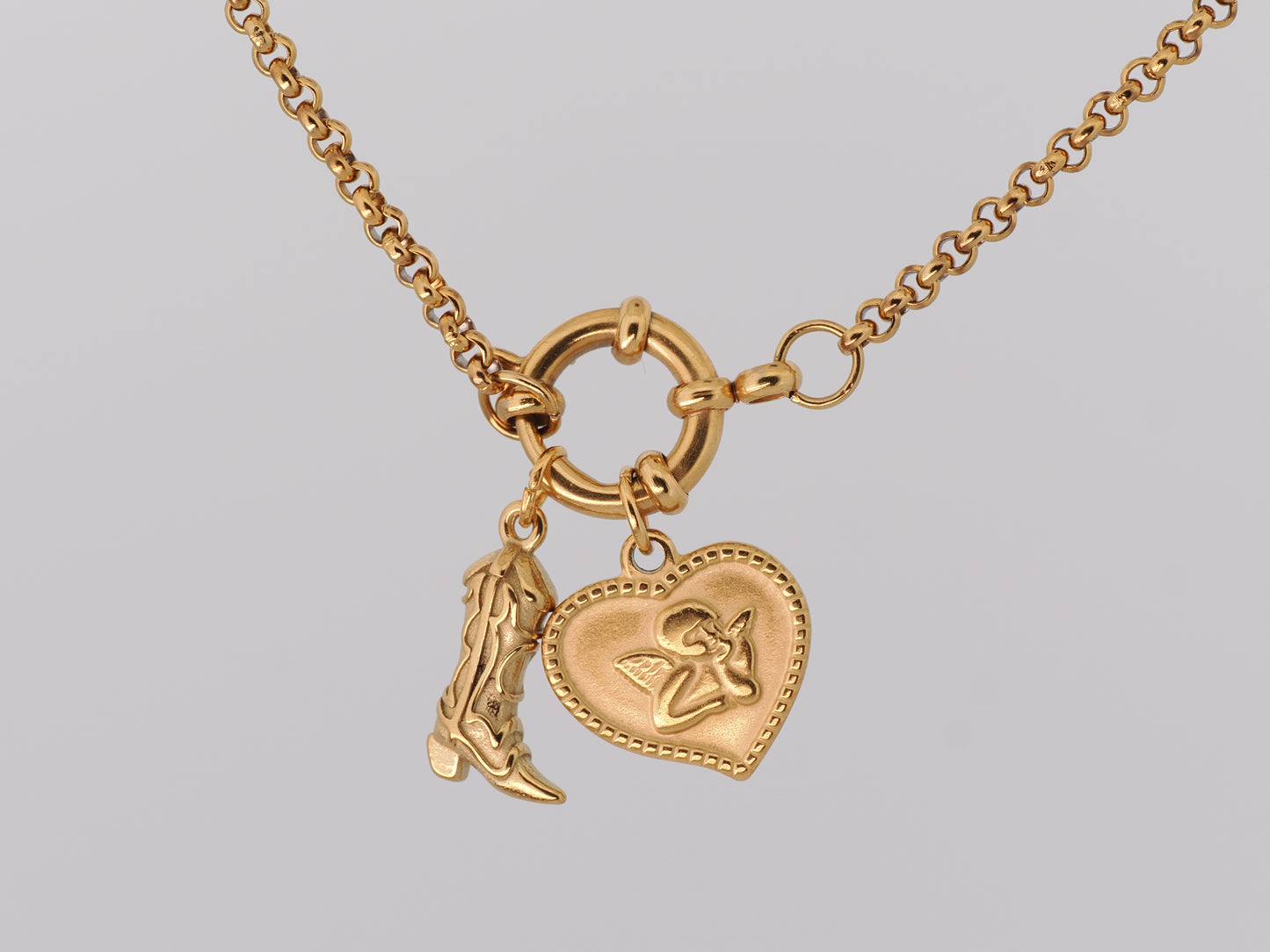 Gold necklace with two charms on a light gray background