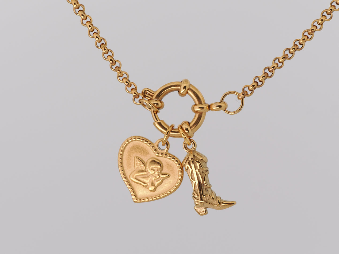 Gold necklace with heart-shaped and boot charm on a gray background