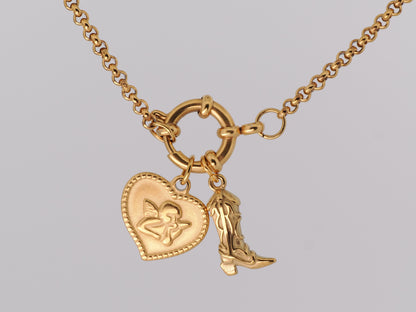 Gold necklace with heart and boot charm on a gray background