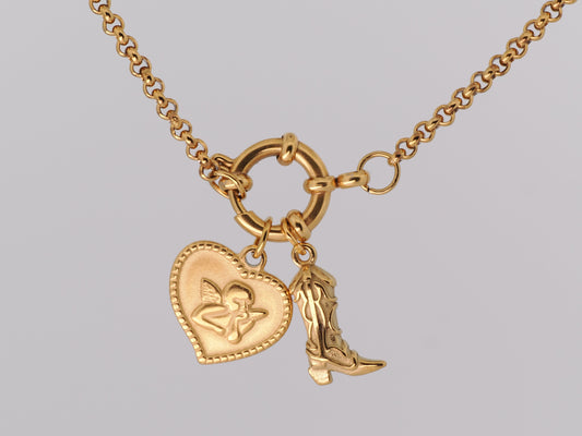 Gold necklace with heart and boot charm on a gray background