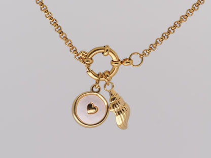 Gold necklace with heart and shell charms on a light gray background