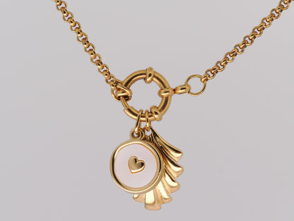 Gold necklace with a heart-shaped pendant on a gray background