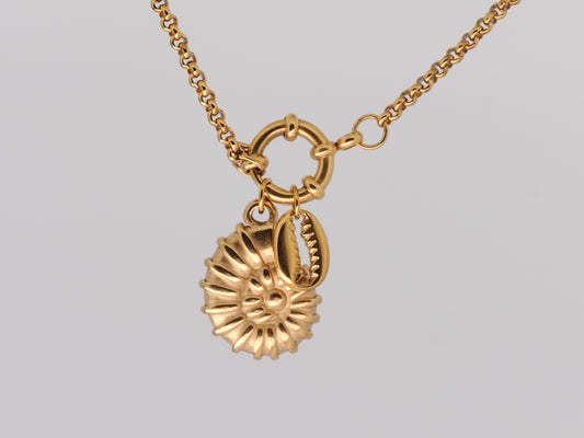 Gold necklace with a detailed pendant on a light gray background