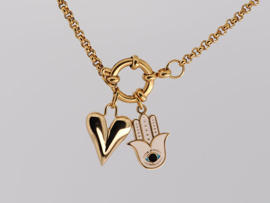 Gold necklace with heart and Hamsa hand pendant on a gray background
