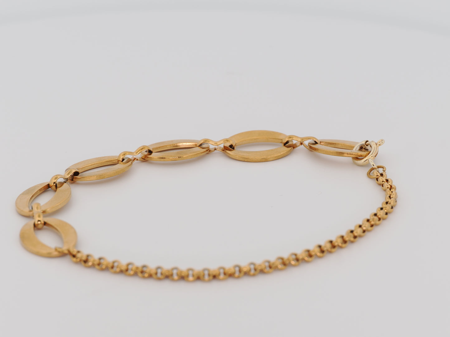 Gold bracelet on a light gray background