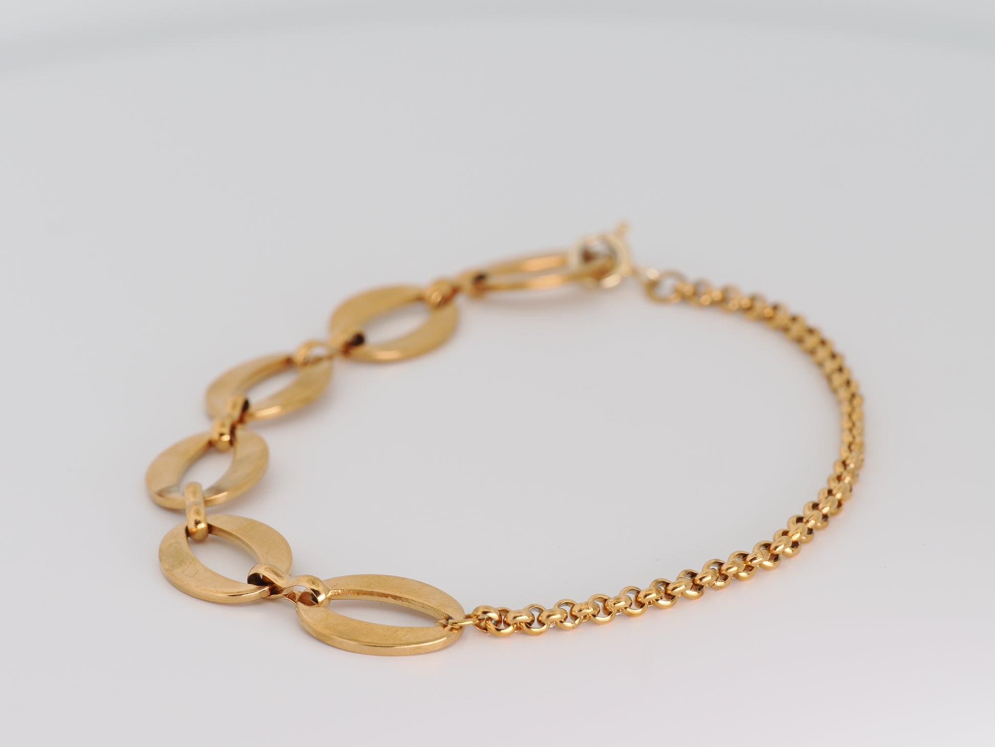 Gold bracelet on a light gray background