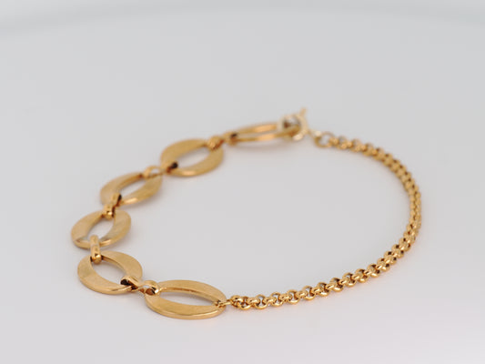 Gold bracelet on a light gray background