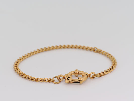 Gold chain bracelet on a light gray background