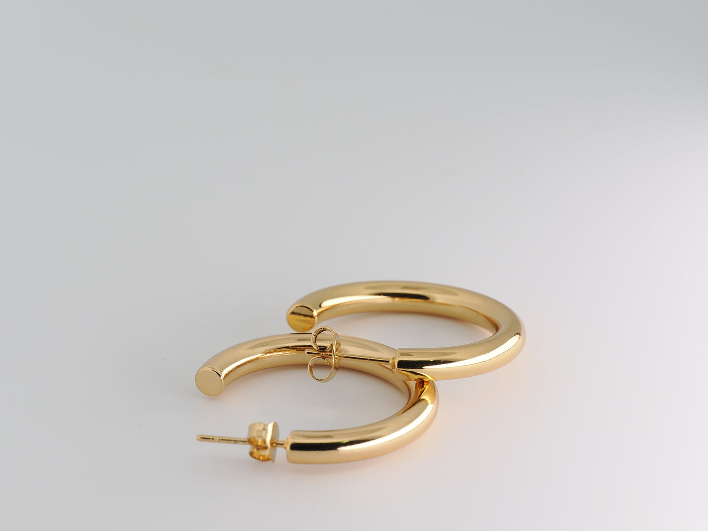 Gold hoop earrings on a light gray background