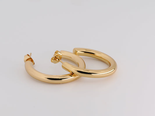 Gold hoop earrings on a light gray background