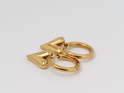 Gold keychain with heart and circular design on a light gray background