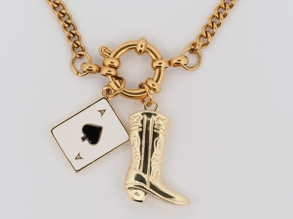 Gold necklace with playing card and cowboy boot charm on a white background