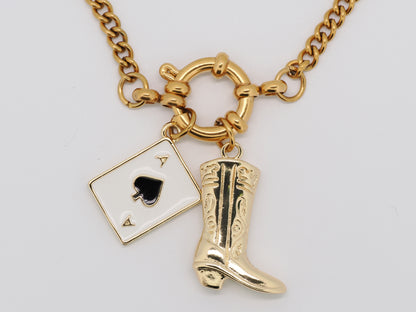 Gold necklace with a spade card and cowboy boot charm on a white background