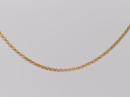 Gold chain necklace on a light gray background
