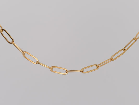 Gold chain necklace on a gray background
