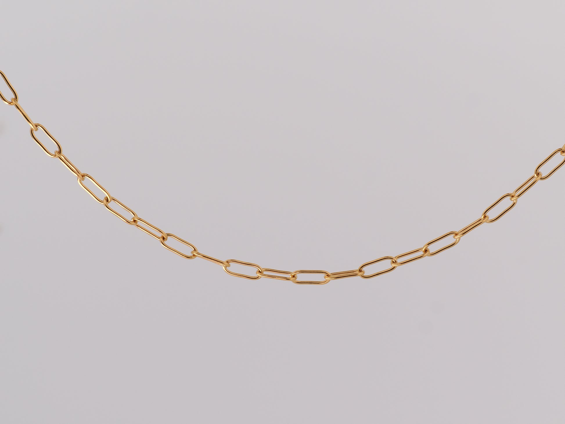 Gold chain on a light gray background