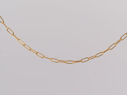 Gold chain on a light gray background
