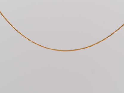Gold chain on a light gray background