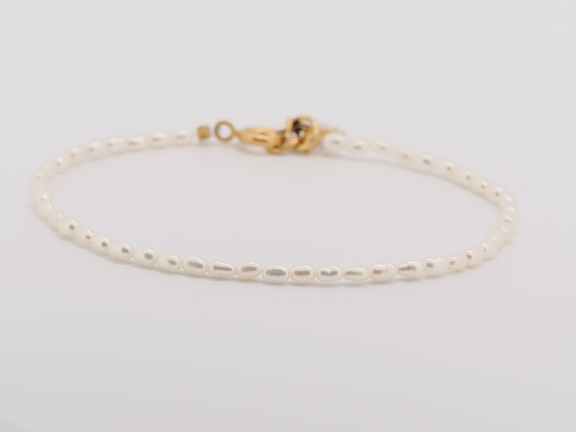 Gold bracelet on a light gray background