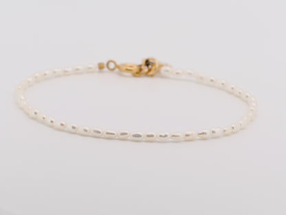 Gold bracelet on a light gray background