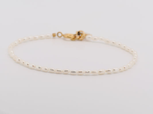Gold bracelet on a light gray background